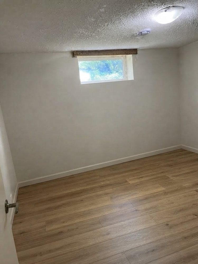 Finished basement room with smooth painted walls and new baseboards